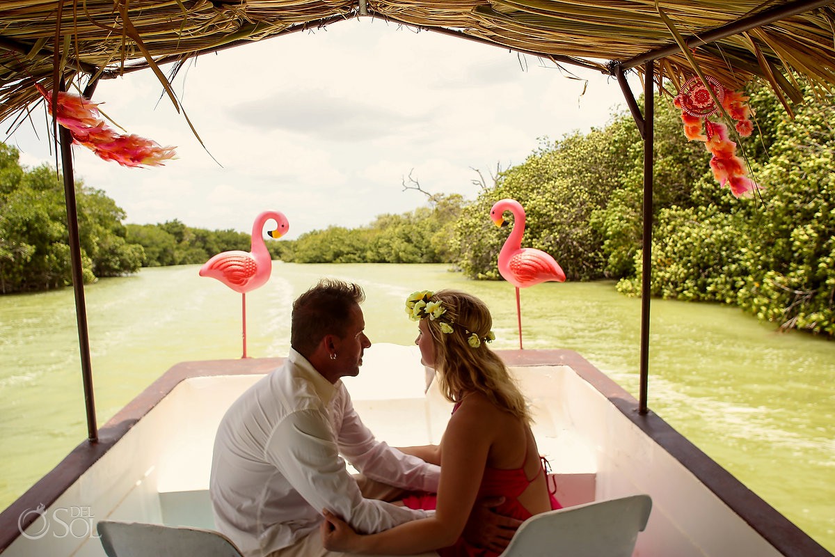 Bride and groom in a flamingo boat on the way to their custom ceremony